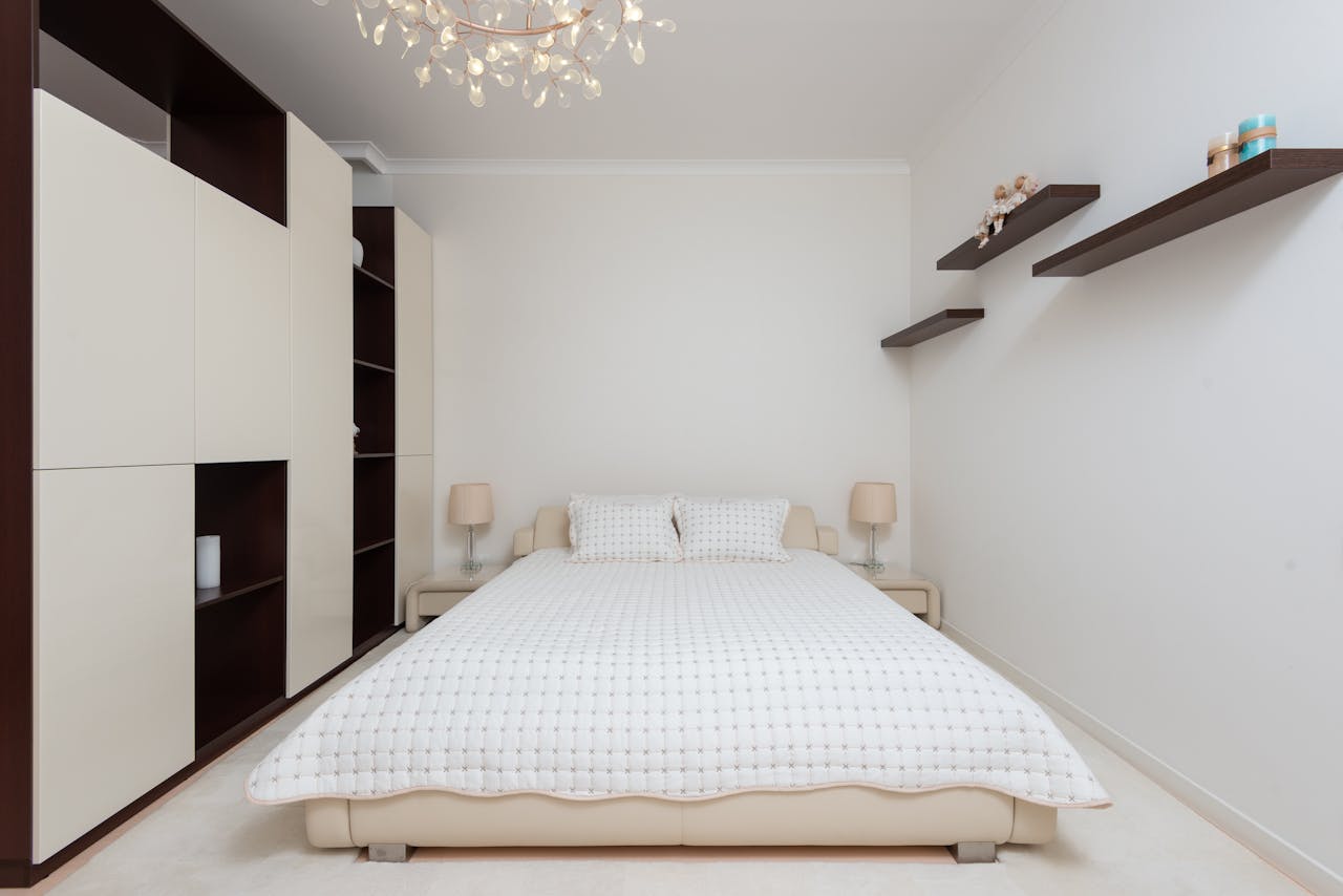 Interior of contemporary large bedroom with black shelves and bed with soft cushions